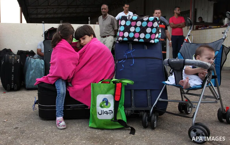 Palestinian chidren sit on a suitcase as they wait with their family for travel permits to cross into Egypt through the Rafah border crossing on October 15, 2016 in the southern Gaza Strip. Egyptian authorities temporari...