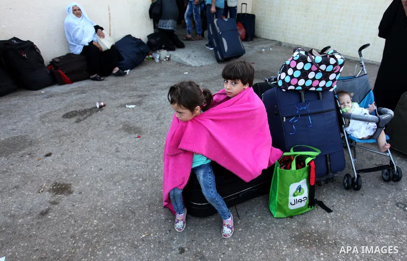 Palestinian chidren sit on a suitcase as they wait with their family for travel permits to cross into Egypt through the Rafah border crossing on October 15, 2016 in the southern Gaza Strip. Egyptian authorities temporari...