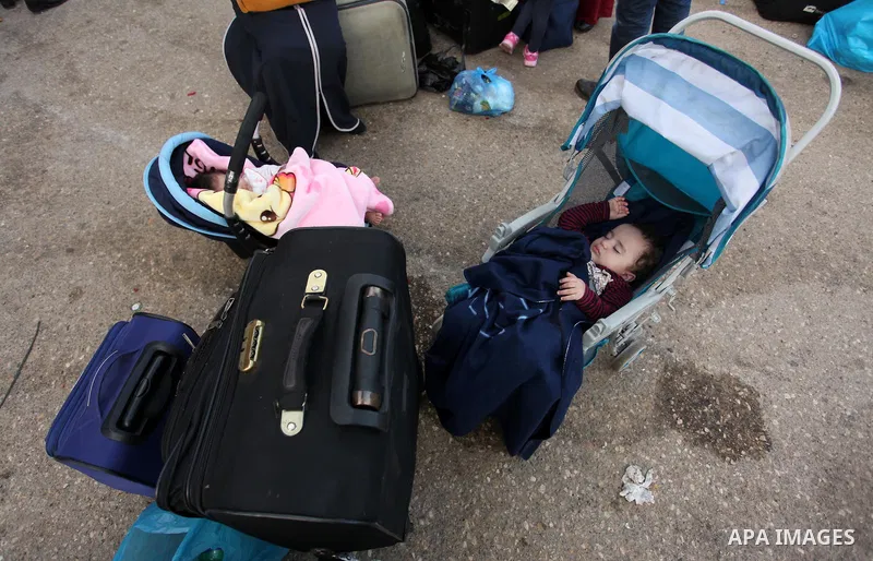 Palestinian childern sleep on a suitcase as they wait with their family for a travel permit to cross into Egypt through the Rafah border crossing on October 15, 2016 in the southern Gaza Strip. Egyptian authorities tempo...