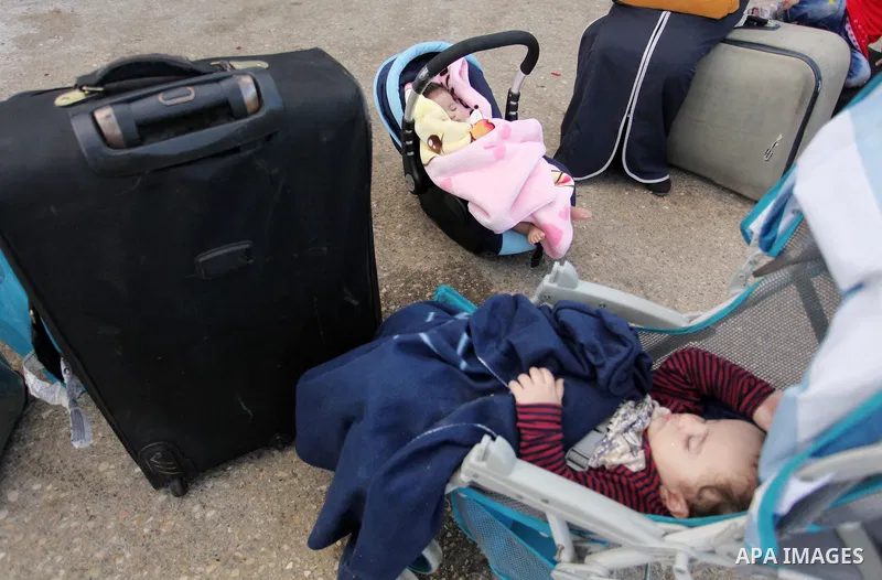 Palestinian childern sleep on a suitcase as they wait with their family for a travel permit to cross into Egypt through the Rafah border crossing on October 15, 2016 in the southern Gaza Strip. Egyptian authorities tempo...