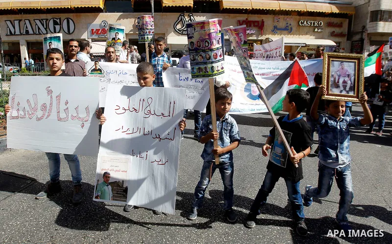 Palestinians take part in a protest demanding Israel return the bodies of Palestinians who allegedly stabbed Israelis, in the West Bank city of Hebron on October 16, 2016. Photo by Wisam Hashlamoun