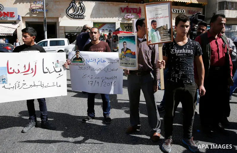 Palestinians take part in a protest demanding Israel return the bodies of Palestinians who allegedly stabbed Israelis, in the West Bank city of Hebron on October 16, 2016. Photo by Wisam Hashlamoun
