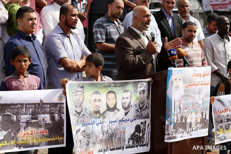 Palestinians hold banners during a rally to mark the prisoner exchange deal that took place in 2011 between Israel and Hamas was under Egyptian auspices, in Rafah in the southern Gaza Strip October 19, 2016. Photo by Abe...