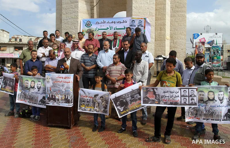 Palestinians hold banners during a rally to mark the prisoner exchange deal that took place in 2011 between Israel and Hamas was under Egyptian auspices, in Rafah in the southern Gaza Strip October 19, 2016. Photo by Abe...