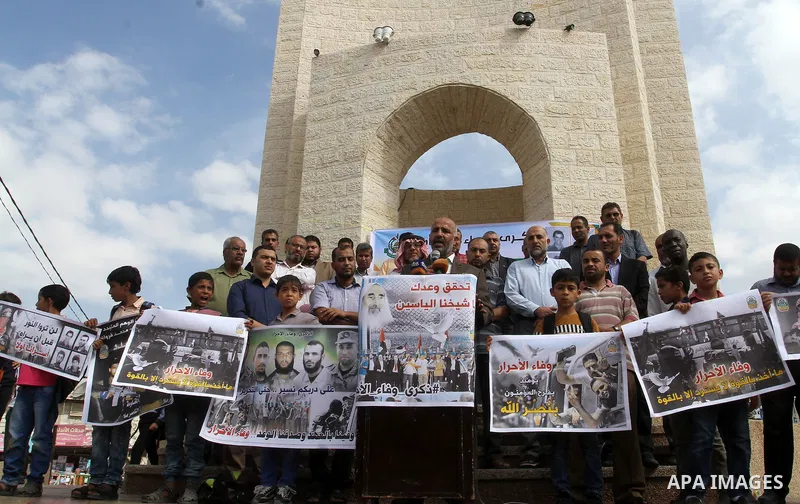 Palestinians hold banners during a rally to mark the prisoner exchange deal that took place in 2011 between Israel and Hamas was under Egyptian auspices, in Rafah in the southern Gaza Strip October 19, 2016. Photo by Abe...