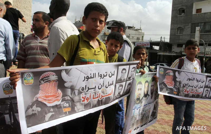 Palestinians hold banners during a rally to mark the prisoner exchange deal that took place in 2011 between Israel and Hamas was under Egyptian auspices, in Rafah in the southern Gaza Strip October 19, 2016. Photo by Abe...