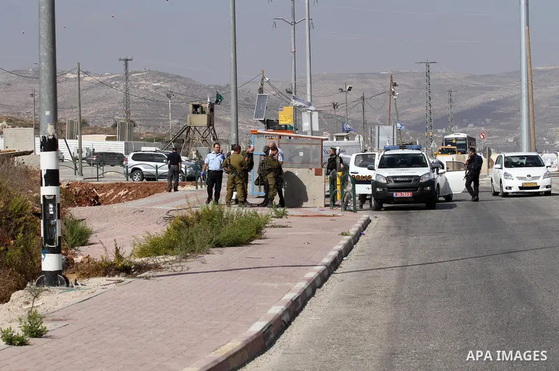 Israeli security forces gather at the site where a Palestinian woman attempted to stab an Israeli border police with a knife before being shot dead, near the Tapuah junction, also known as the Zaatara junction, south of...