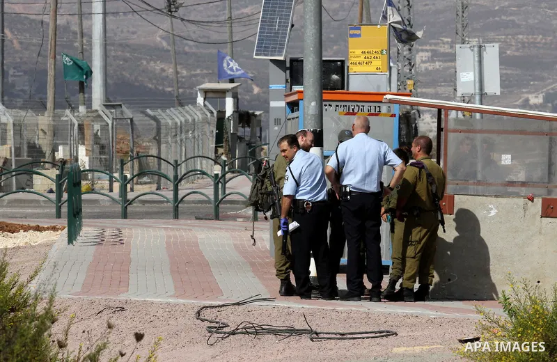 Israeli security forces gather at the site where a Palestinian woman attempted to stab an Israeli border police with a knife before being shot dead, near the Tapuah junction, also known as the Zaatara junction, south of...