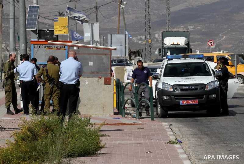 Israeli security forces gather at the site where a Palestinian woman attempted to stab an Israeli border police with a knife before being shot dead, near the Tapuah junction, also known as the Zaatara junction, south of...