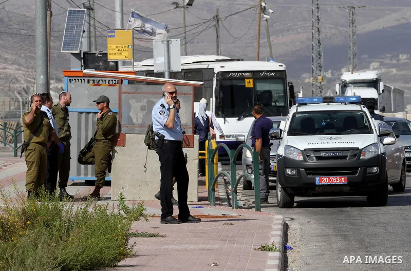 Israeli security forces gather at the site where a Palestinian woman attempted to stab an Israeli border police with a knife before being shot dead, near the Tapuah junction, also known as the Zaatara junction, south of...