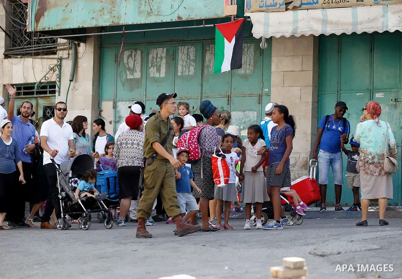 Israeli settlers visit the Jewish shrine of Atnaeil Ben Kinaz during the Jewish Sukkot holiday or the feast of the Tabernacles in a Palestinian neighbourhood of the divided West Bank city of Hebron on Oct. 19, 2016. Phot...