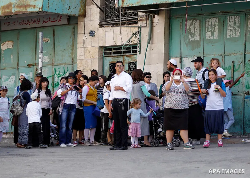 Israeli settlers visit the Jewish shrine of Atnaeil Ben Kinaz during the Jewish Sukkot holiday or the feast of the Tabernacles in a Palestinian neighbourhood of the divided West Bank city of Hebron on Oct. 19, 2016. Phot...
