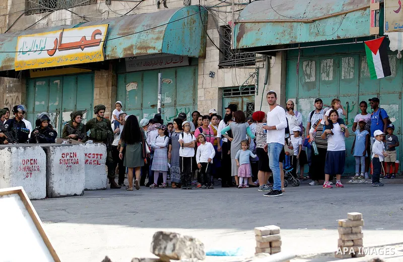 Israeli settlers visit the Jewish shrine of Atnaeil Ben Kinaz during the Jewish Sukkot holiday or the feast of the Tabernacles in a Palestinian neighbourhood of the divided West Bank city of Hebron on Oct. 19, 2016. Phot...