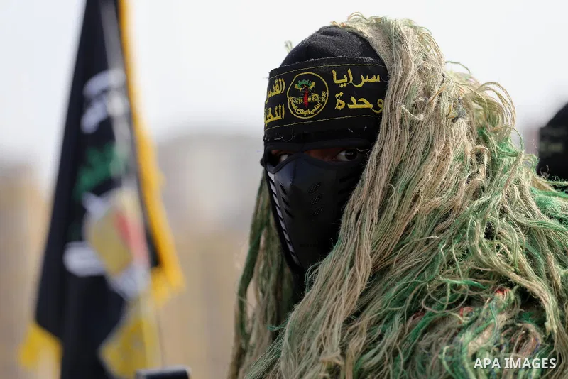 A Palestinian Islamic Jihad militant stands guard on a roof during a rally marking the 29th anniversary of the movement foundation in Gaza City October 21, 2016. Photo by Mohammed Asad