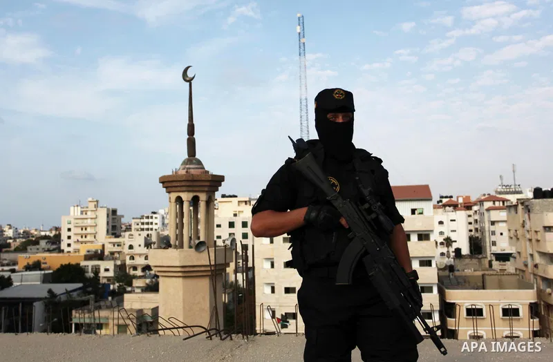 A Palestinian Islamic Jihad militant stands guard on a roof during a rally marking the 29th anniversary of the movement foundation in Gaza City October 21, 2016. Photo by Ashraf Amra