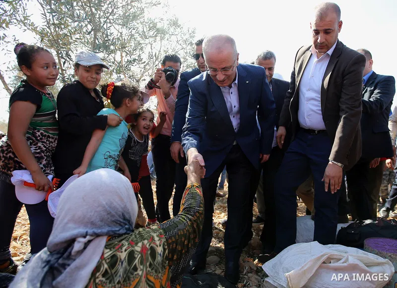 Palestinian Prime Minister Rami Hamdallah takes part during harvest season at a farm in the West Bank city of Qalqilya, on Oct. 22, 2016. Photo by Prime Minister Office