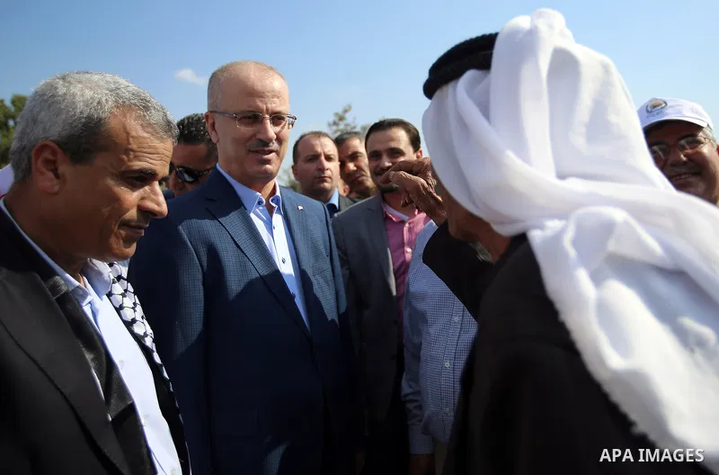 Palestinian Prime Minister Rami Hamdallah takes part during harvest season at a farm in the West Bank city of Qalqilya, on Oct. 22, 2016. Photo by Prime Minister Office