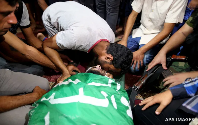 Relatives of a Palestinian member of the Ezzedine al-Qassam Brigades, the armed wing of the Hamas Anas Salama Abu Lasheen, 22, who died after a tunnel collapse in the Gaza Strip mourn during his funeral, in the al-Maghaz...
