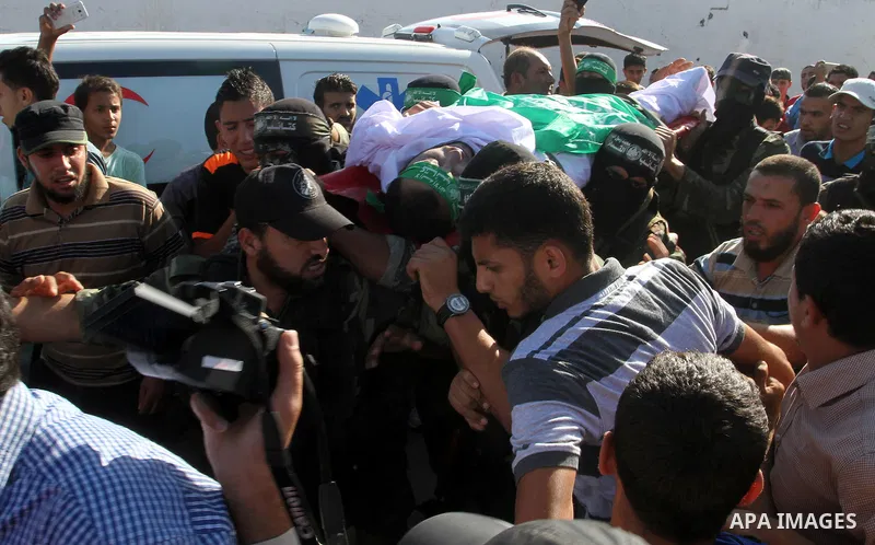 Members of the Ezzedine al-Qassam Brigades, the military wing of the Palestinian Islamist movement Hamas, carry the body of a fellow Palestinian militant, Amir Jaber Abu Taimeh, during his funeral in Khan Yunis in the so...