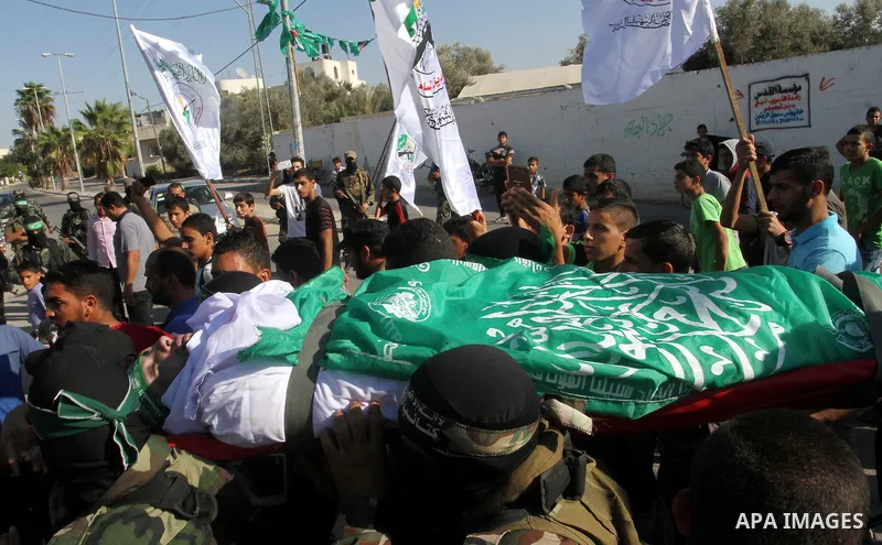 Members of the Ezzedine al-Qassam Brigades, the military wing of the Palestinian Islamist movement Hamas, carry the body of a fellow Palestinian militant, Amir Jaber Abu Taimeh, during his funeral in Khan Yunis in the so...