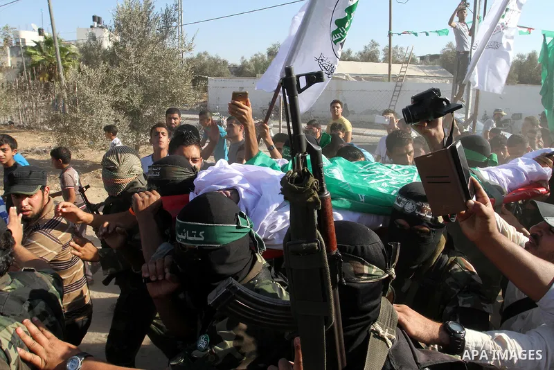Members of the Ezzedine al-Qassam Brigades, the military wing of the Palestinian Islamist movement Hamas, carry the body of a fellow Palestinian militant, Amir Jaber Abu Taimeh, during his funeral in Khan Yunis in the so...