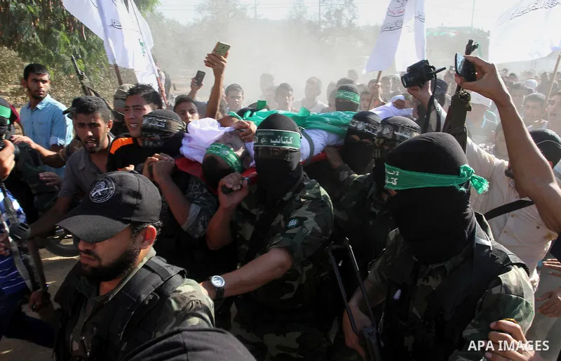 Members of the Ezzedine al-Qassam Brigades, the military wing of the Palestinian Islamist movement Hamas, carry the body of a fellow Palestinian militant, Amir Jaber Abu Taimeh, during his funeral in Khan Yunis in the so...