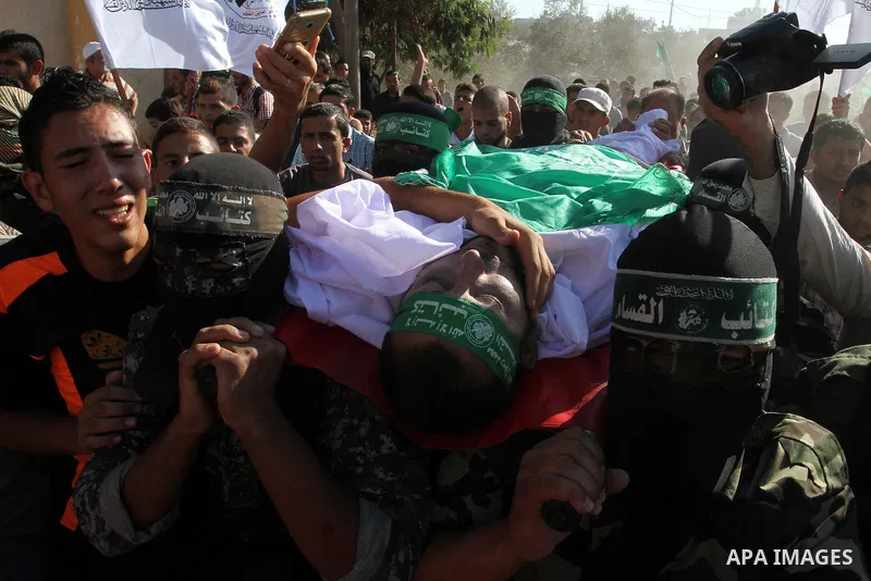 Members of the Ezzedine al-Qassam Brigades, the military wing of the Palestinian Islamist movement Hamas, carry the body of a fellow Palestinian militant, Amir Jaber Abu Taimeh, during his funeral in Khan Yunis in the so...