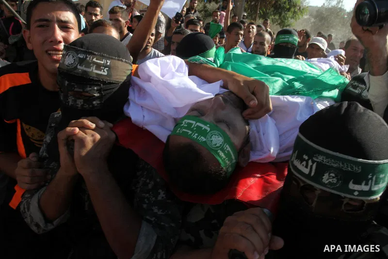Members of the Ezzedine al-Qassam Brigades, the military wing of the Palestinian Islamist movement Hamas, carry the body of a fellow Palestinian militant, Amir Jaber Abu Taimeh, during his funeral in Khan Yunis in the so...