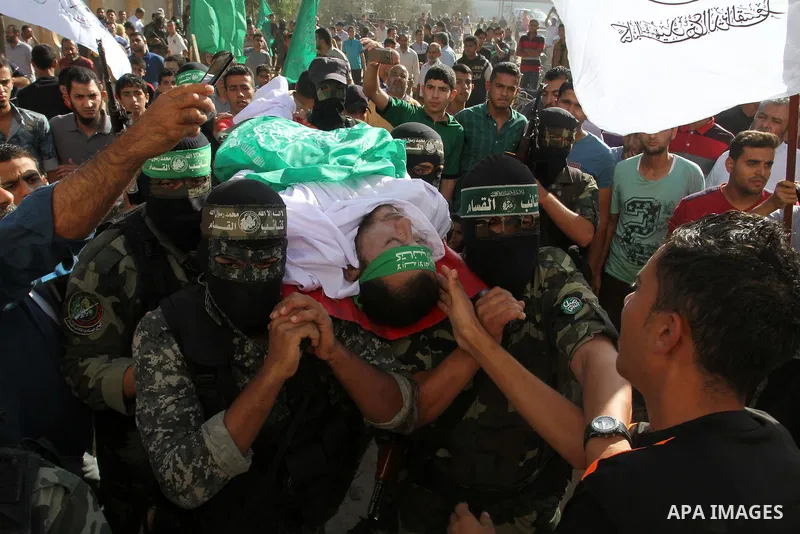 Members of the Ezzedine al-Qassam Brigades, the military wing of the Palestinian Islamist movement Hamas, carry the body of a fellow Palestinian militant, Amir Jaber Abu Taimeh, during his funeral in Khan Yunis in the so...