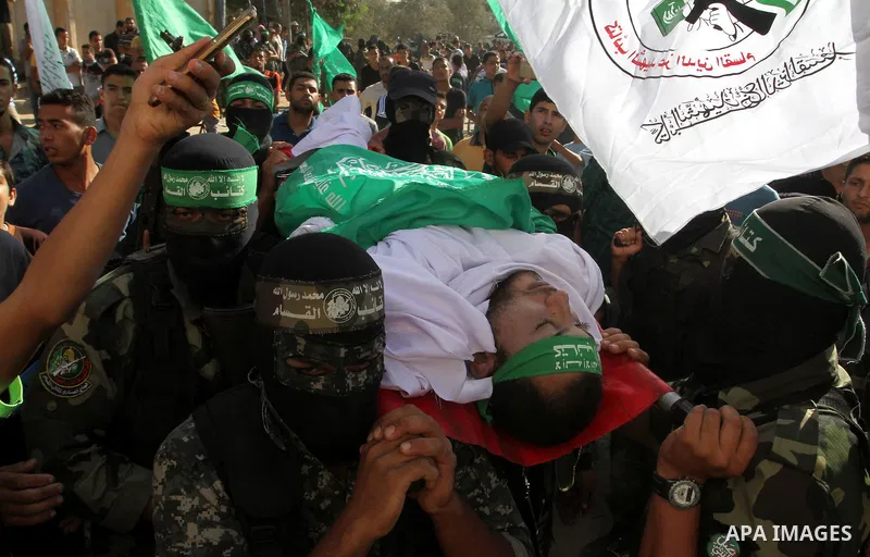 Members of the Ezzedine al-Qassam Brigades, the military wing of the Palestinian Islamist movement Hamas, carry the body of a fellow Palestinian militant, Amir Jaber Abu Taimeh, during his funeral in Khan Yunis in the so...