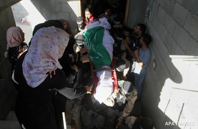 Members of the Ezzedine al-Qassam Brigades, the military wing of the Palestinian Islamist movement Hamas, carry the body of a fellow Palestinian militant, Amir Jaber Abu Taimeh, during his funeral in Khan Yunis in the so...