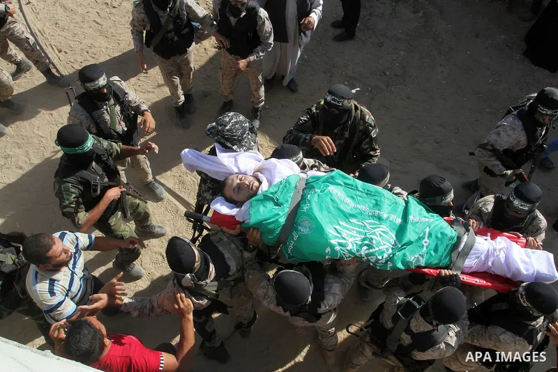 Members of the Ezzedine al-Qassam Brigades, the military wing of the Palestinian Islamist movement Hamas, carry the body of a fellow Palestinian militant, Amir Jaber Abu Taimeh, during his funeral in Khan Yunis in the so...