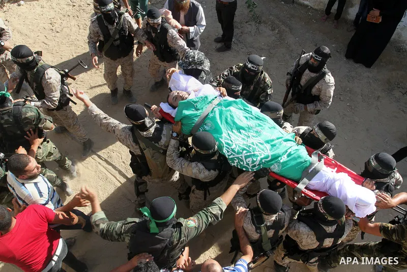 Members of the Ezzedine al-Qassam Brigades, the military wing of the Palestinian Islamist movement Hamas, carry the body of a fellow Palestinian militant, Amir Jaber Abu Taimeh, during his funeral in Khan Yunis in the so...