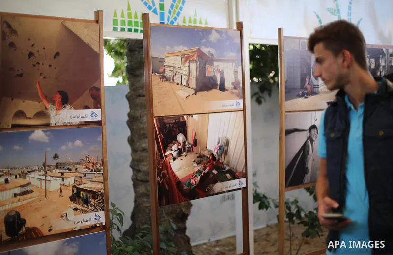 Palestinians attend a photo gallery, in Gaza City, on October 25, 2016. Photo by Mohammed Asad