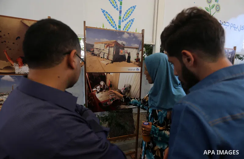 Palestinians attend a photo gallery, in Gaza City, on October 25, 2016. Photo by Mohammed Asad