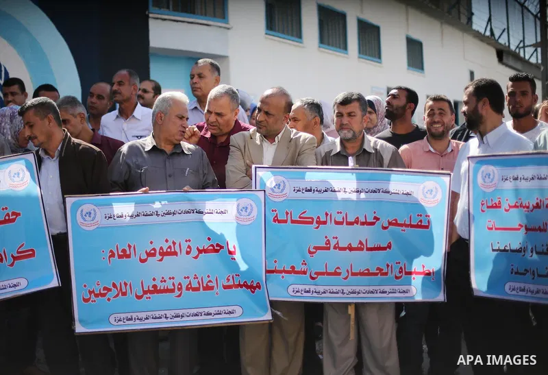 Palestinians hold banners during a protest against the UNRWA decision to reduce of the aid in front of the headquarters United Nations Relief and Works Agency (UNRWA), in Gaza city, on October 25, 2016. Photo by Mohammed...