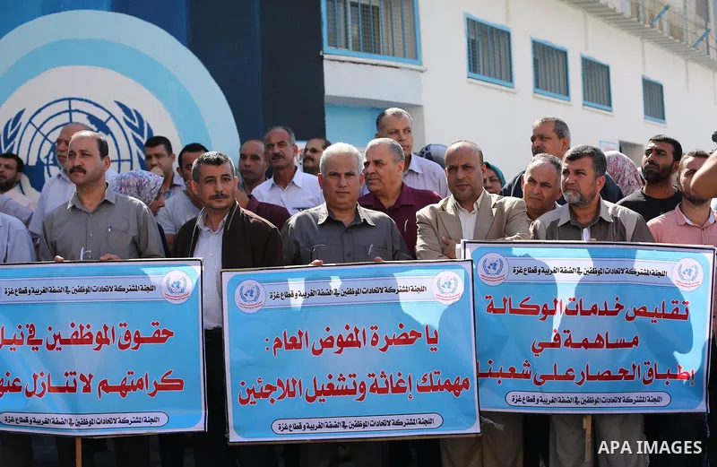 Palestinians hold banners during a protest against the UNRWA decision to reduce of the aid in front of the headquarters United Nations Relief and Works Agency (UNRWA), in Gaza city, on October 25, 2016. Photo by Mohammed...