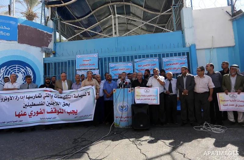 Palestinians hold banners during a protest against the UNRWA decision to reduce of the aid in front of the headquarters United Nations Relief and Works Agency (UNRWA), in Gaza city, on October 25, 2016. Photo by Mohammed...
