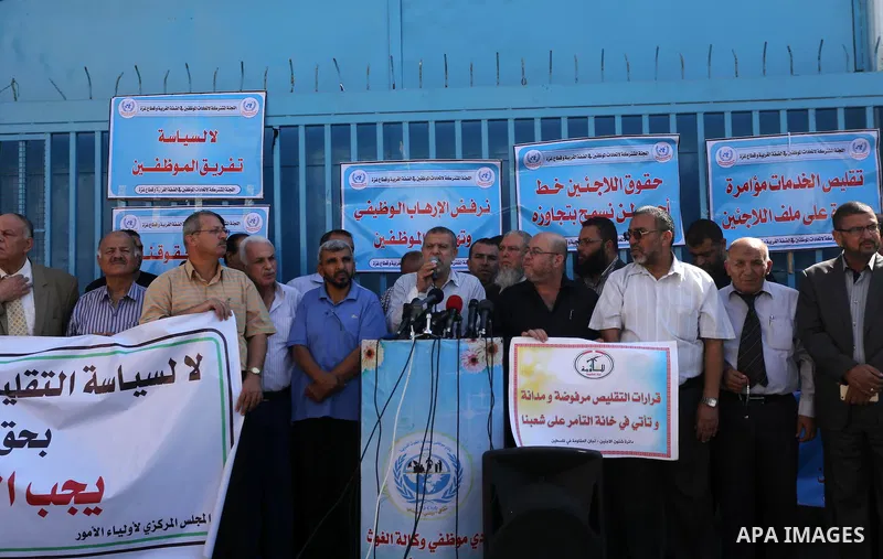 Palestinians hold banners during a protest against the UNRWA decision to reduce of the aid in front of the headquarters United Nations Relief and Works Agency (UNRWA), in Gaza city, on October 25, 2016. Photo by Mohammed...