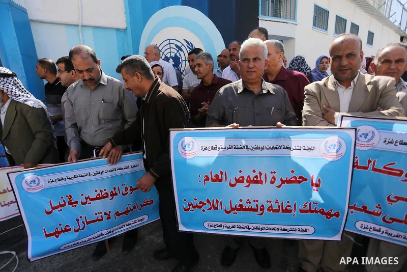 Palestinians hold banners during a protest against the UNRWA decision to reduce of the aid in front of the headquarters United Nations Relief and Works Agency (UNRWA), in Gaza city, on October 25, 2016. Photo by Mohammed...