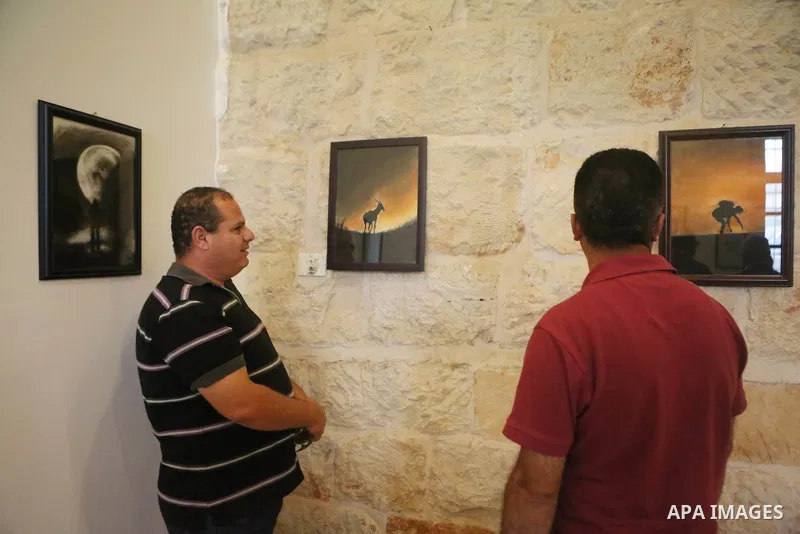 Palestinians attend a drawing exhibition titled "Tales of coffee-flavored", in the West Bank city of Ramallah, on October 25, 2016. Photo by Shadi Hatem