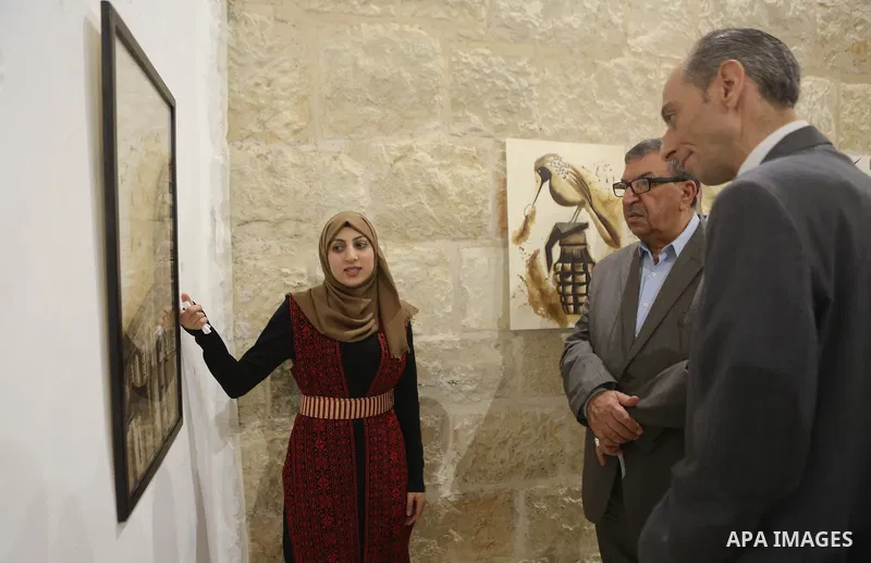 Palestinians attend a drawing exhibition titled "Tales of coffee-flavored", in the West Bank city of Ramallah, on October 25, 2016. Photo by Shadi Hatem