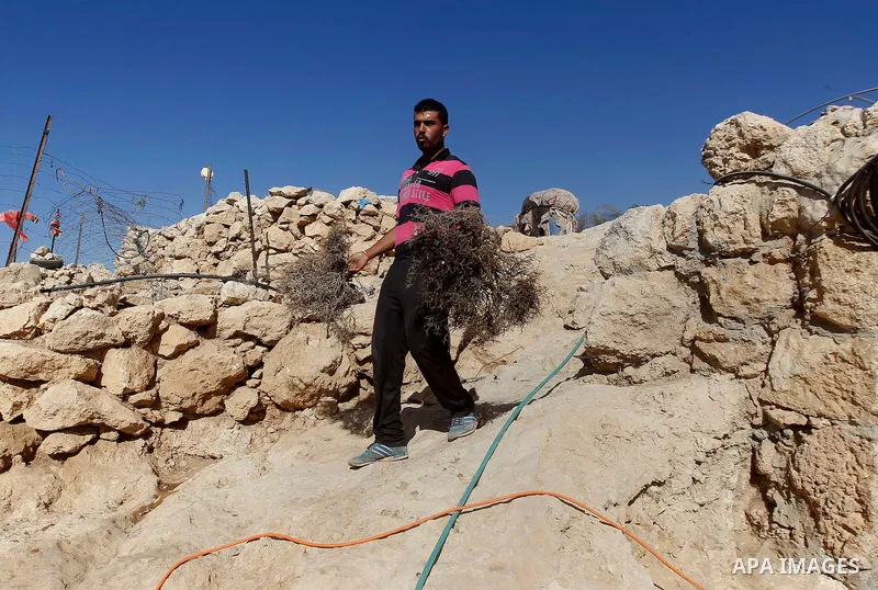 A Palestinian man of Hawamdeh family walks outside a cave he lives in, in West Bank village of Mufagara, south of Hebron on Oct. 25, 2016. Photo by Wisam Hashlamoun