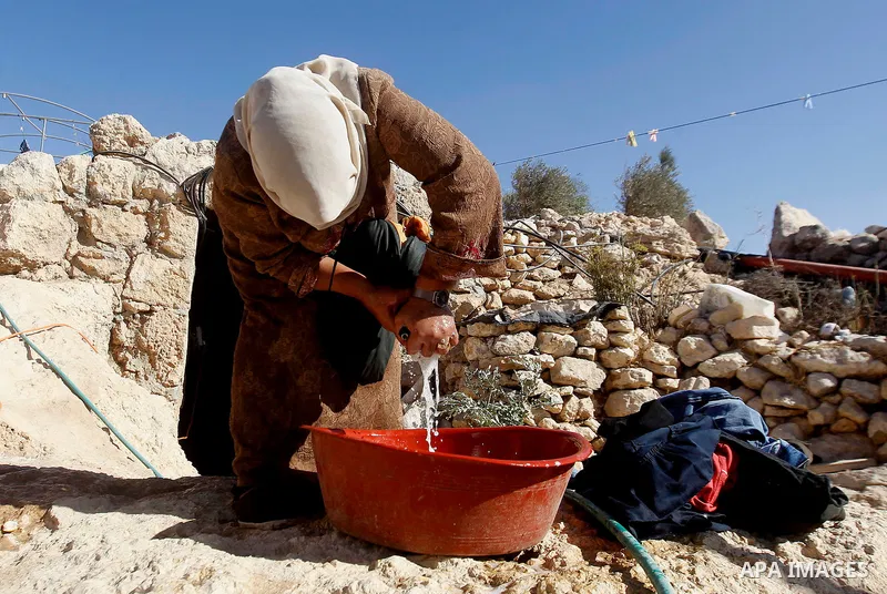 A Palestinian woman of Hawamdeh family washes clothes outside a cave she lives in, in West Bank village of Mufagara, south of Hebron on Oct. 25, 2016. Photo by Wisam Hashlamoun