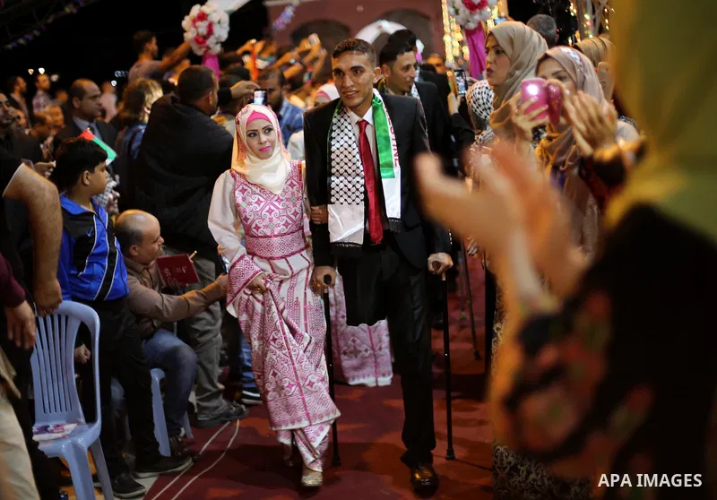 Palestinian grooms and brides take part in a mass wedding ceremony in Gaza city on Oct. 25, 2016. Nearly 20 Palestinian couples from War-wounded were married in a ceremony funded by the UAE government. Photo by Mohammed...