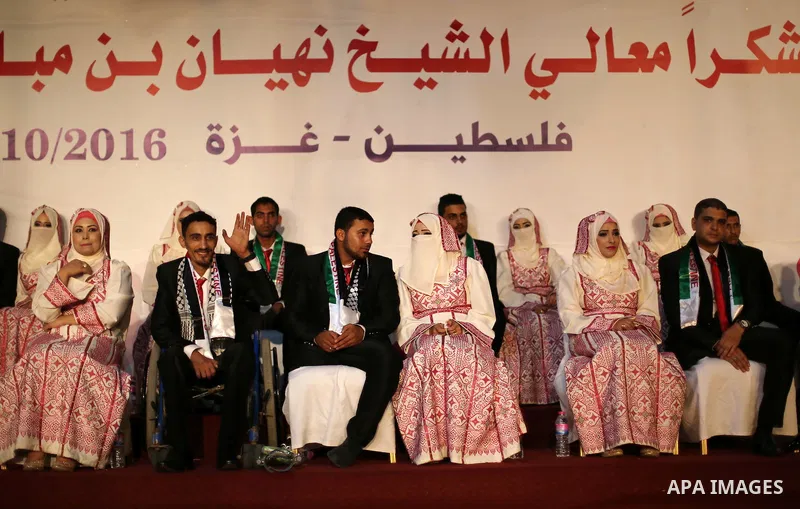 Palestinian grooms and brides take part in a mass wedding ceremony in Gaza city on Oct. 25, 2016. Nearly 20 Palestinian couples from War-wounded were married in a ceremony funded by the UAE government. Photo by Mohammed...