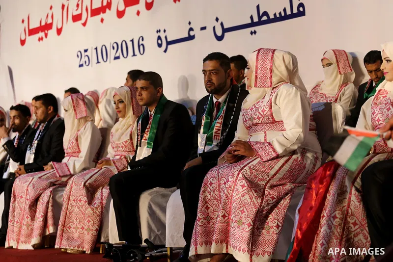 Palestinian grooms and brides take part in a mass wedding ceremony in Gaza city on Oct. 25, 2016. Nearly 20 Palestinian couples from War-wounded were married in a ceremony funded by the UAE government. Photo by Mohammed...