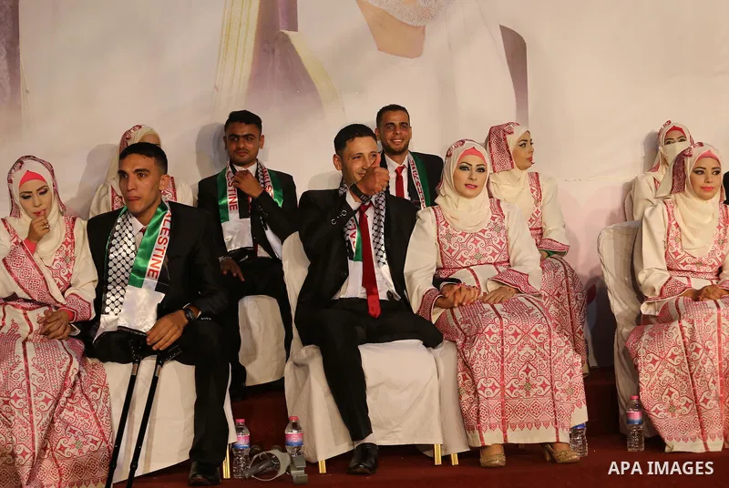 Palestinian grooms and brides take part in a mass wedding ceremony in Gaza city on Oct. 25, 2016. Nearly 20 Palestinian couples from War-wounded were married in a ceremony funded by the UAE government. Photo by Mohammed...