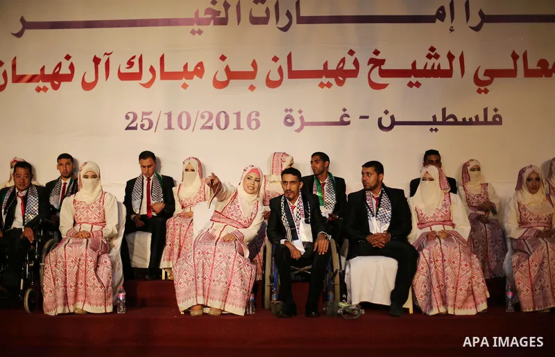 Palestinian grooms and brides take part in a mass wedding ceremony in Gaza city on Oct. 25, 2016. Nearly 20 Palestinian couples from War-wounded were married in a ceremony funded by the UAE government. Photo by Mohammed...