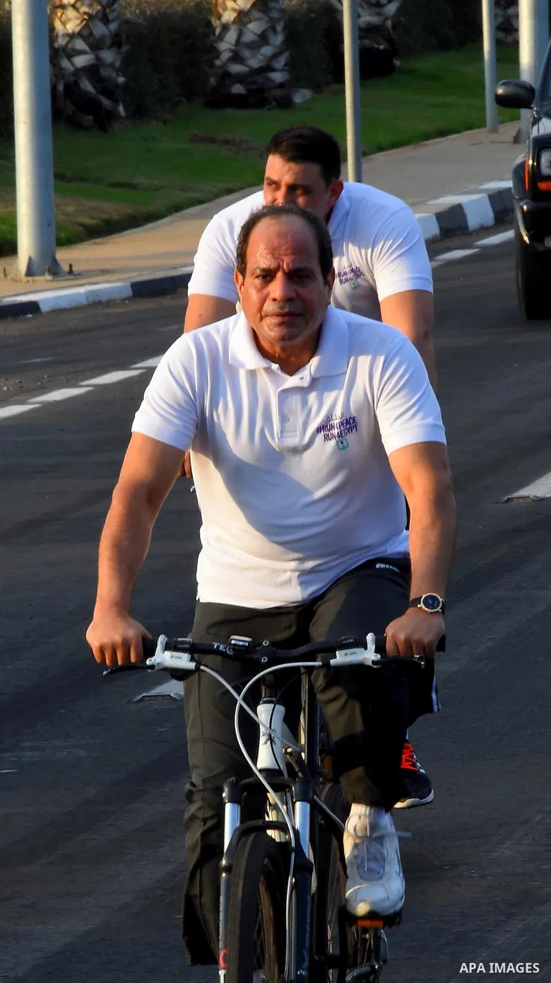 Egyptian President Abdel Fattah al-Sisi rides a bicycle at the street in the Red Sea resort of Sharm Al-Sheikh, in the South Sinai governorate, south of Cairo, Egypt, on Oct. 26, 2016. Photo by Egyptian President Office